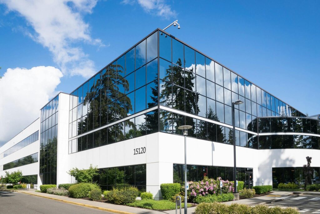 pexels-photo-269077-269077 Contemporary office building in Redmond with reflective glass and lush greenery, captured on a sunny day.